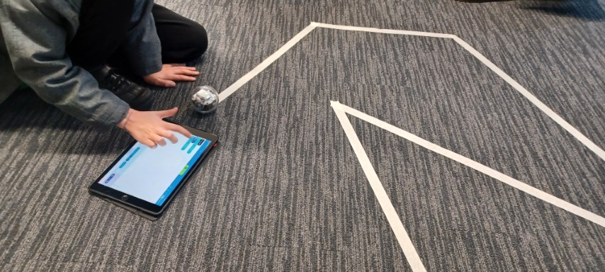 Children programming Sphero robots to follow taped lines on the floor at Leeds Central Library Code Club